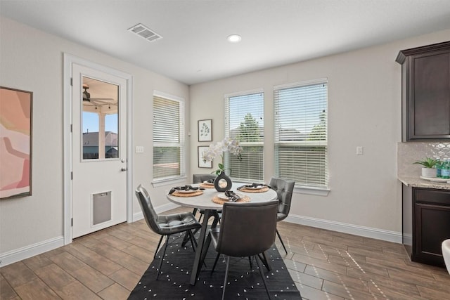 dining room featuring visible vents, wood finished floors, and baseboards