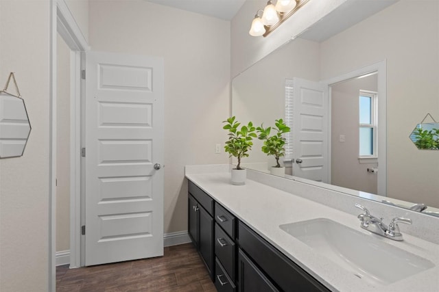 bathroom with baseboards, vanity, and wood finished floors