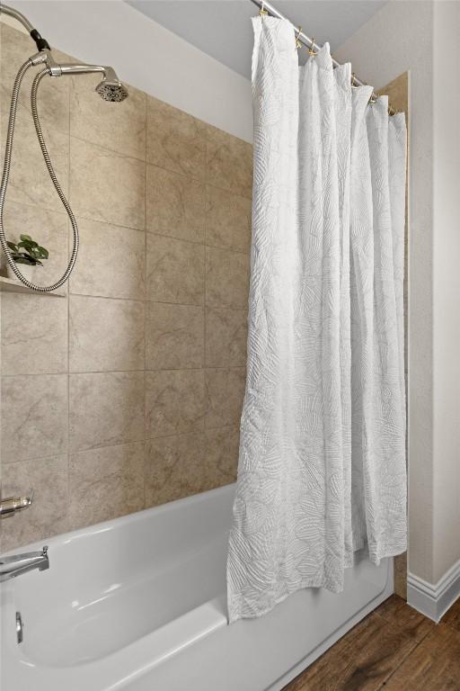full bathroom with shower / bathtub combination with curtain and wood finished floors