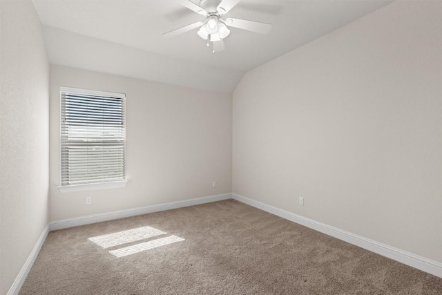 empty room featuring baseboards, ceiling fan, carpet, and vaulted ceiling
