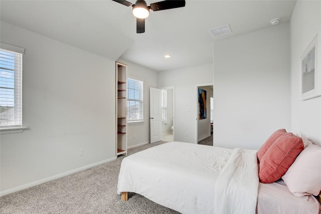 930 Blue Oak Blvd, San Marcos, TX 78666 - carpeted bedroom with multiple windows, baseboards, ceiling fan, and ensuite bathroom
