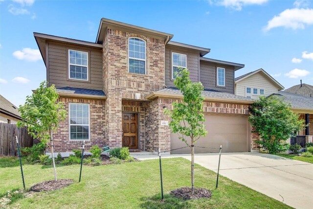view of front of home featuring brick siding, fence, an attached garage, concrete driveway, and a front lawn