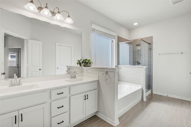 full bath with a bath, a shower stall, and a sink