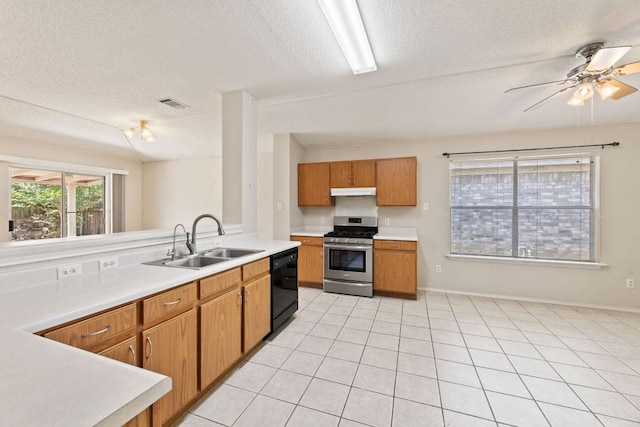 kitchen with gas range, a sink, black dishwasher, a textured ceiling, and light countertops