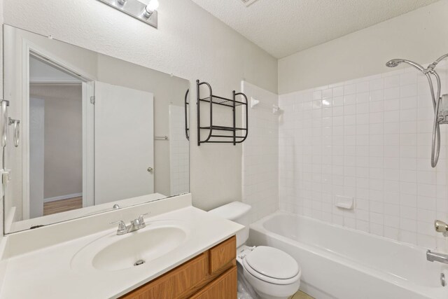bathroom with toilet, a textured ceiling, bathtub / shower combination, and vanity