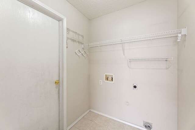 1216 Acanthus St, Pflugerville, TX 78660 - laundry area with hookup for an electric dryer, hookup for a washing machine, light tile patterned floors, and baseboards
