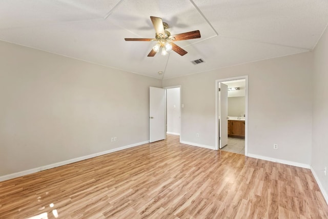 unfurnished bedroom with light wood-style floors, baseboards, connected bathroom, and ceiling fan