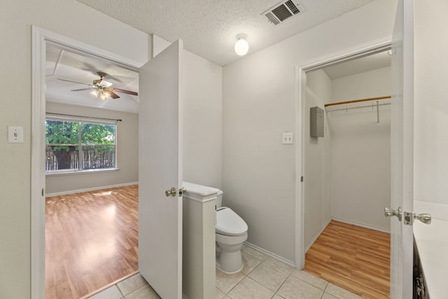1216 Acanthus St, Pflugerville, TX 78660 - bathroom featuring toilet, ceiling fan, a textured ceiling, tile patterned flooring, and baseboards