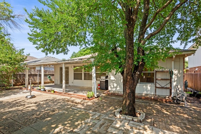 rear view of house with a patio and fence
