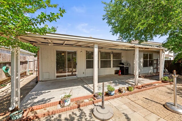 back of property featuring fence and a patio