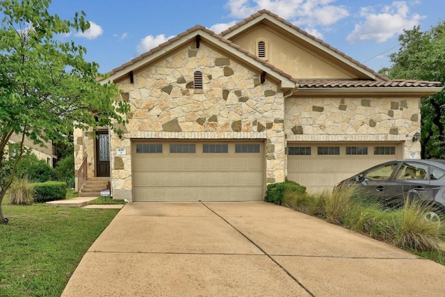 400 Hummingbird Ln Unit A, Austin, TX 78734 - view of front of home with stone siding, concrete driveway, an attached garage, and a tiled roof
