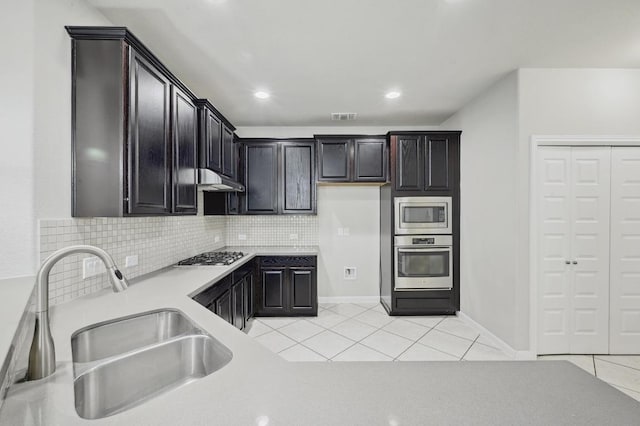 400 Hummingbird Ln Unit A, Austin, TX 78734 - kitchen with appliances with stainless steel finishes, light tile patterned flooring, tasteful backsplash, light countertops, and under cabinet range hood