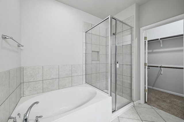 400 Hummingbird Ln Unit A, Austin, TX 78734 - bathroom with a garden tub, a walk in closet, a shower stall, and tile patterned flooring