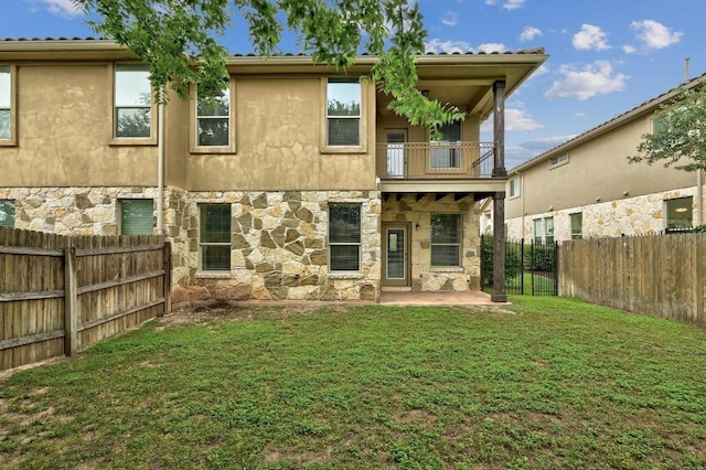 400 Hummingbird Ln Unit A, Austin, TX 78734 - back of property with stone siding, a balcony, a fenced backyard, and a patio area