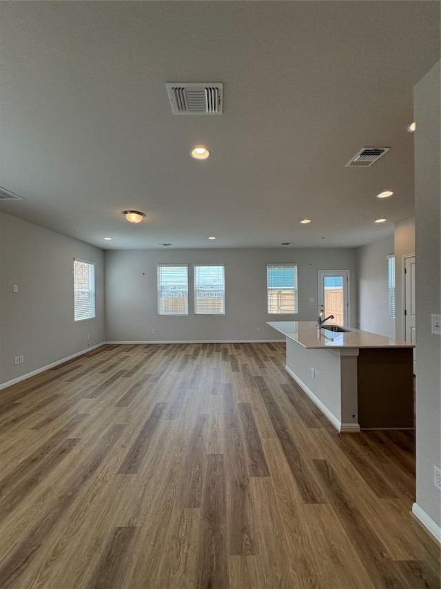 108 Elm Branch Trl, Taylor, TX 76574 - unfurnished living room featuring wood finished floors, plenty of natural light, and recessed lighting