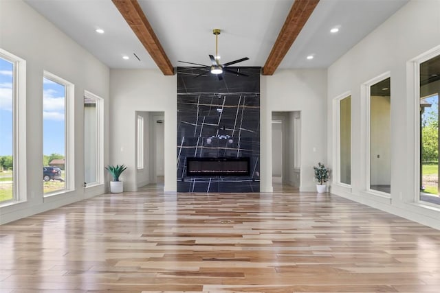 17109 Saint Therese Rd, Manor, TX 78653 - unfurnished living room featuring wood finished floors, ceiling fan, beam ceiling, recessed lighting, and a premium fireplace