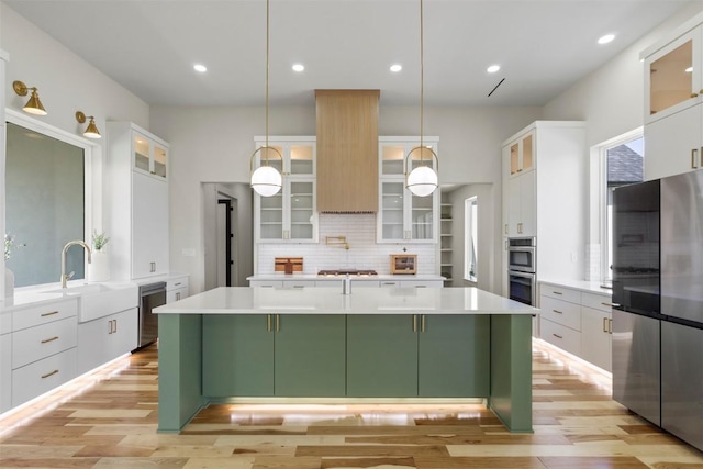 17109 Saint Therese Rd, Manor, TX 78653 - kitchen featuring stainless steel appliances, green cabinets, white cabinetry, decorative backsplash, and a kitchen island
