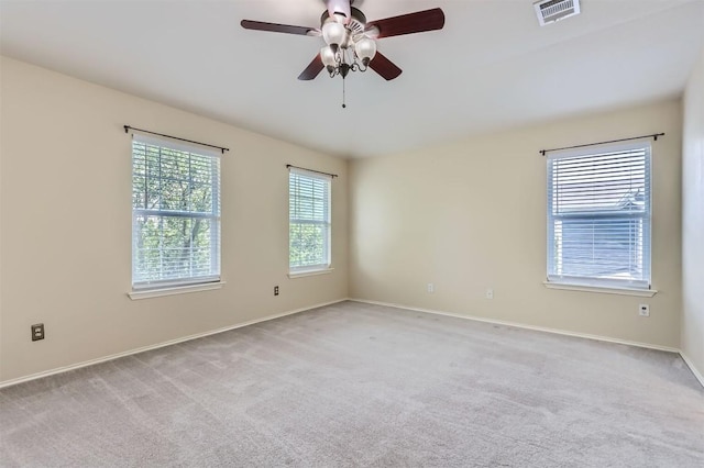 empty room featuring a ceiling fan, baseboards, visible vents, and carpet