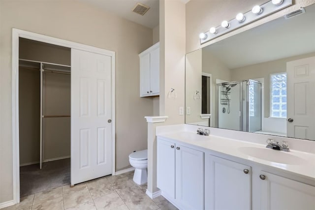 bathroom with a stall shower, toilet, visible vents, and a sink