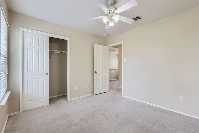 unfurnished bedroom with a closet, visible vents, ceiling fan, carpet floors, and baseboards