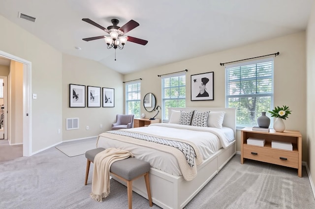 bedroom with vaulted ceiling, light colored carpet, baseboards, and visible vents