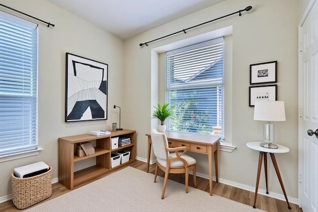office space with baseboards and wood finished floors