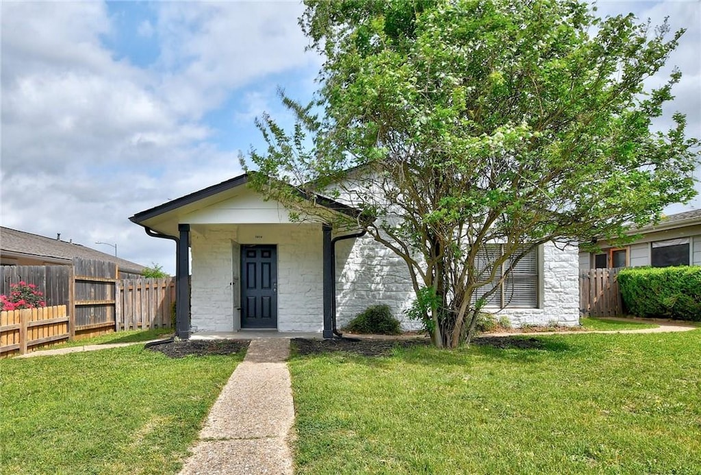 5604 Pinon Vista Dr, Austin, TX 78724 - bungalow-style house with stone siding, a front lawn, and fence