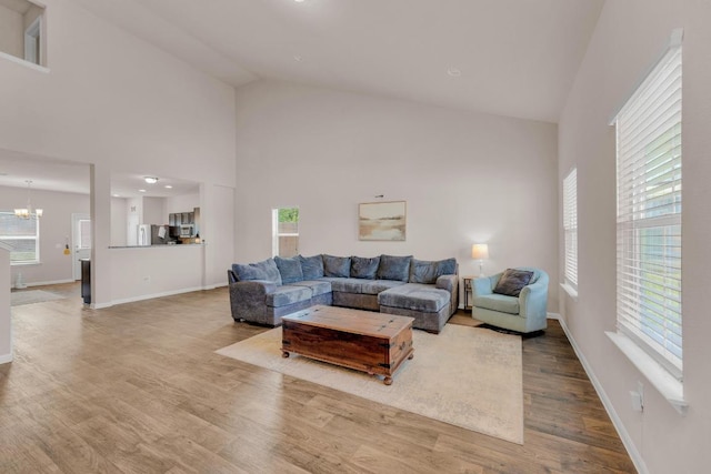 310 Garcitas Creek Ln, Hutto, TX 78634 - living area featuring high vaulted ceiling, wood finished floors, a chandelier, plenty of natural light, and baseboards