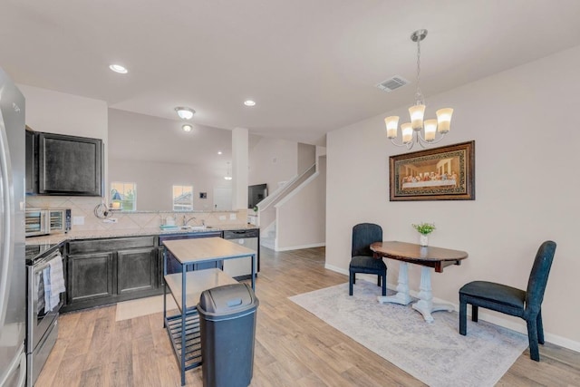 310 Garcitas Creek Ln, Hutto, TX 78634 - kitchen with light countertops, appliances with stainless steel finishes, backsplash, a chandelier, and a peninsula