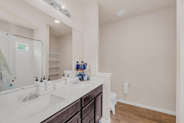 310 Garcitas Creek Ln, Hutto, TX 78634 - full bathroom featuring toilet, double vanity, wood finished floors, baseboards, and a shower