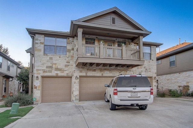 1310 W Parmer Ln Unit 2701, Austin, TX 78727 - view of front of property with stone siding, driveway, an attached garage, and a balcony
