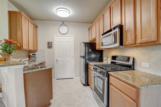 1310 W Parmer Ln Unit 2701, Austin, TX 78727 - kitchen featuring a peninsula, light brown cabinetry, a sink, stainless steel appliances, and decorative backsplash