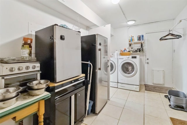 laundry area featuring light tile patterned floors, washing machine and dryer, and laundry area