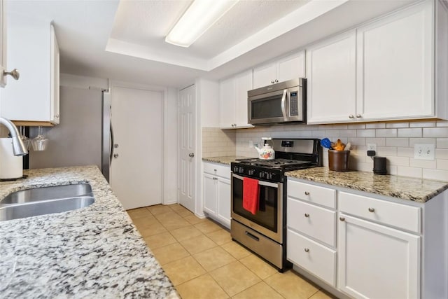 1610 Old Tract Rd, Pflugerville, TX 78660 - kitchen featuring appliances with stainless steel finishes, a sink, white cabinets, and backsplash
