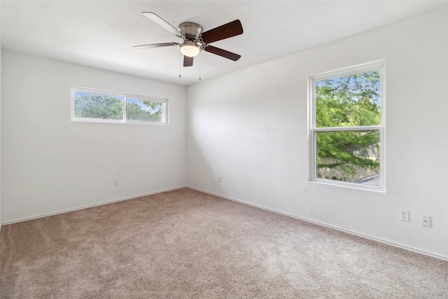 spare room with ceiling fan, carpet flooring, and baseboards