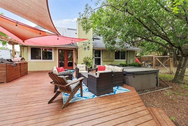 wooden deck with french doors, a hot tub, outdoor lounge area, fence, and a grill