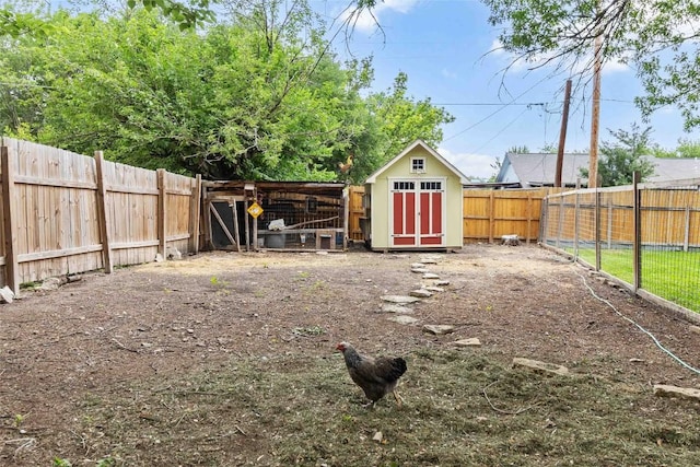 view of yard with a storage shed, an outdoor structure, and a fenced backyard