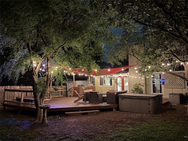 back of property with an outdoor living space, a wooden deck, and a hot tub