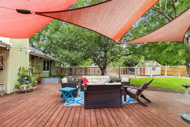 wooden terrace with an outdoor structure, a storage shed, a yard, an outdoor living space, and a fenced backyard