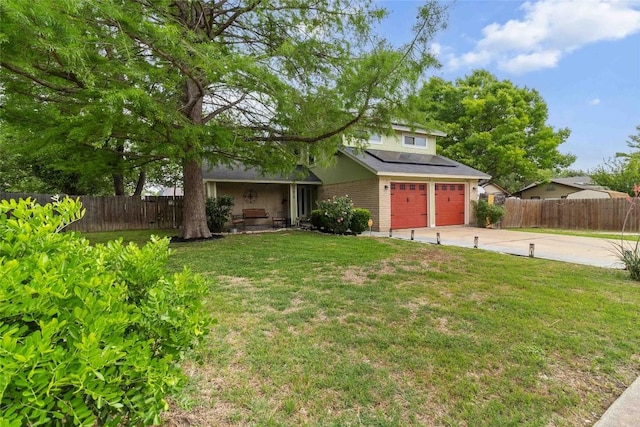 traditional-style house featuring a front lawn, fence, driveway, and solar panels