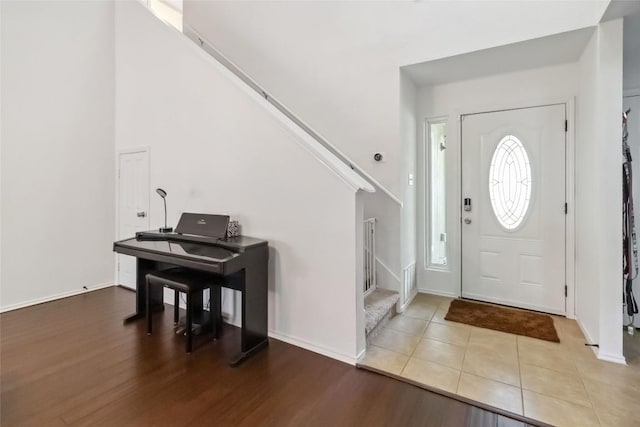 foyer with stairs, baseboards, and wood finished floors