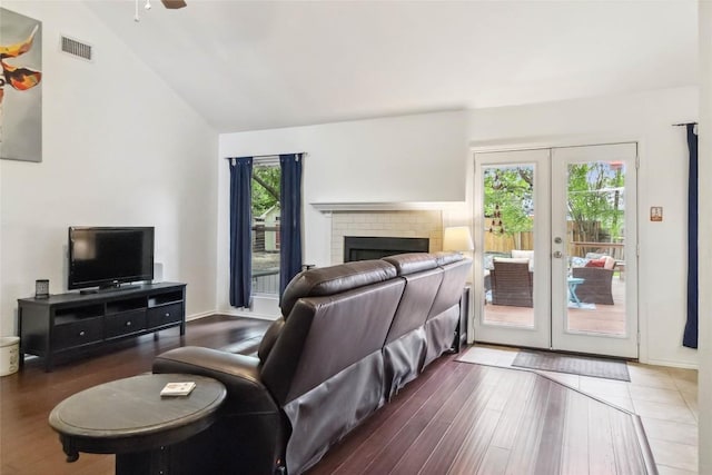 living room with a wealth of natural light, visible vents, french doors, and lofted ceiling