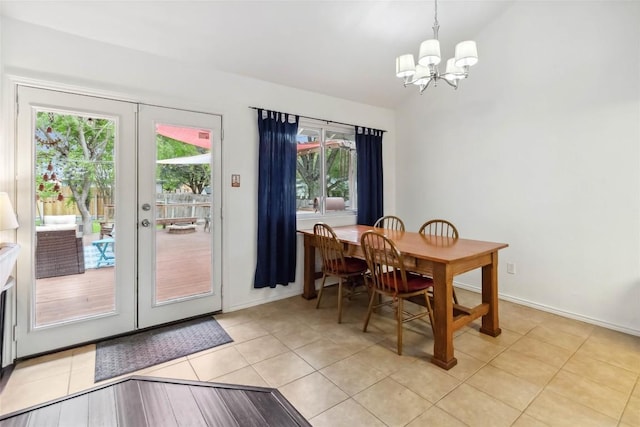 dining area with a notable chandelier, french doors, baseboards, light tile patterned flooring, and vaulted ceiling