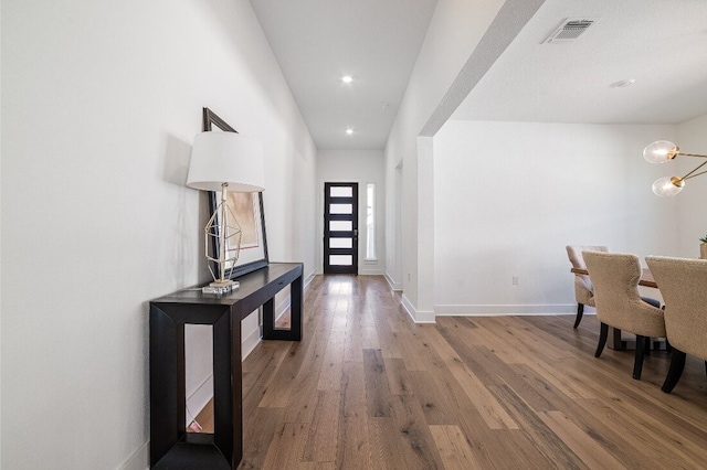 9413 Flatbush Dr, Austin, TX 78744 - entrance foyer featuring wood finished floors, baseboards, visible vents, recessed lighting, and a notable chandelier