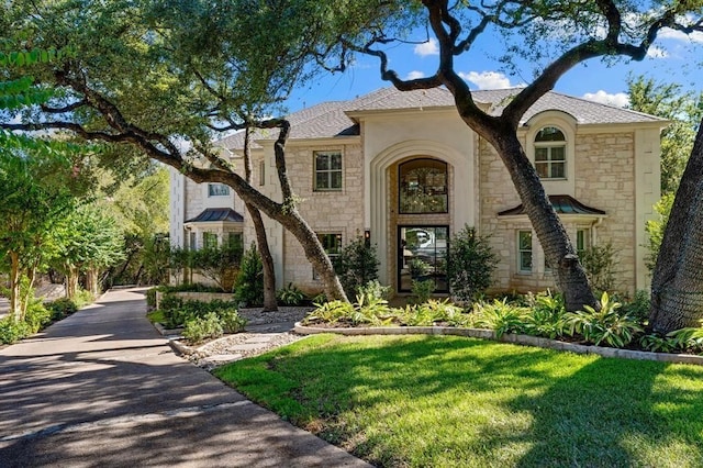 2901 Meandering River Ct, Austin, TX 78746 - view of front of home with roof with shingles, stone siding, and a front yard