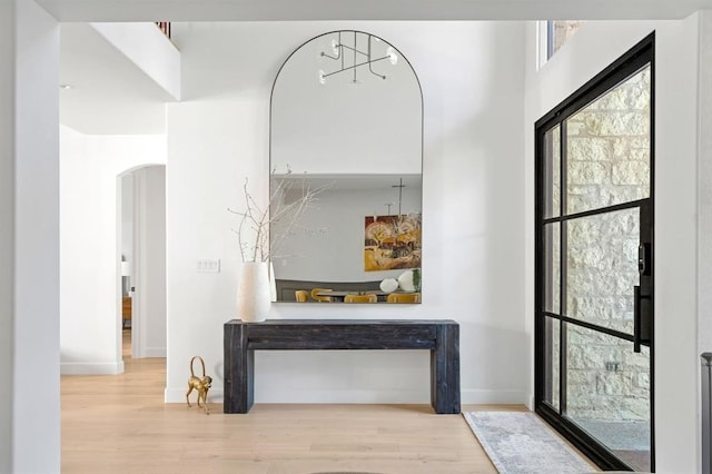2901 Meandering River Ct, Austin, TX 78746 - hall featuring arched walkways, wood finished floors, healthy amount of natural light, and baseboards