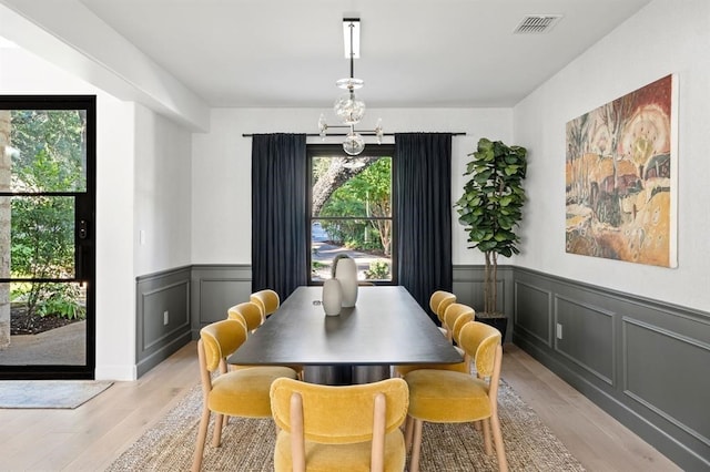 2901 Meandering River Ct, Austin, TX 78746 - dining space with light wood-style floors, a wainscoted wall, a chandelier, and a decorative wall