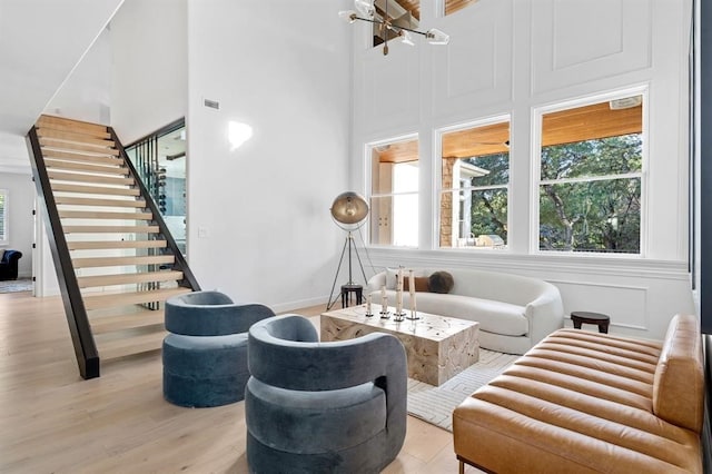 2901 Meandering River Ct, Austin, TX 78746 - living room with stairway, light wood-style floors, and a high ceiling