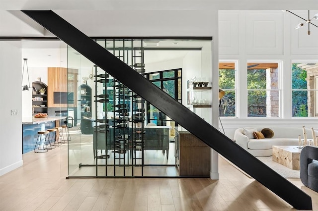 2901 Meandering River Ct, Austin, TX 78746 - stairs featuring wood finished floors and a chandelier