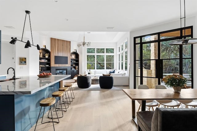 2901 Meandering River Ct, Austin, TX 78746 - kitchen featuring a sink, healthy amount of natural light, light stone counters, and hanging light fixtures